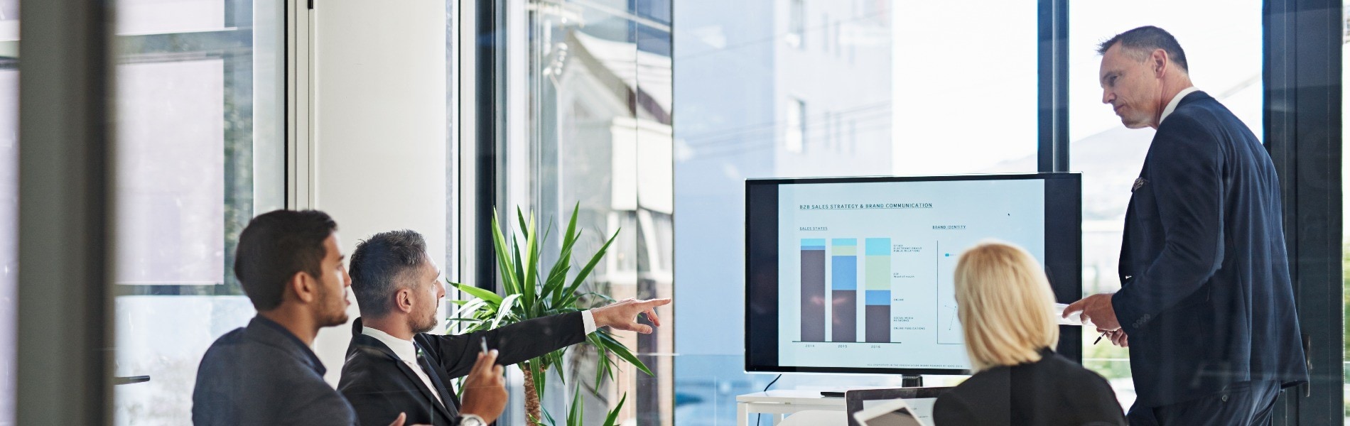 Professionals discussing strategy based on the data listed on the screen. 
