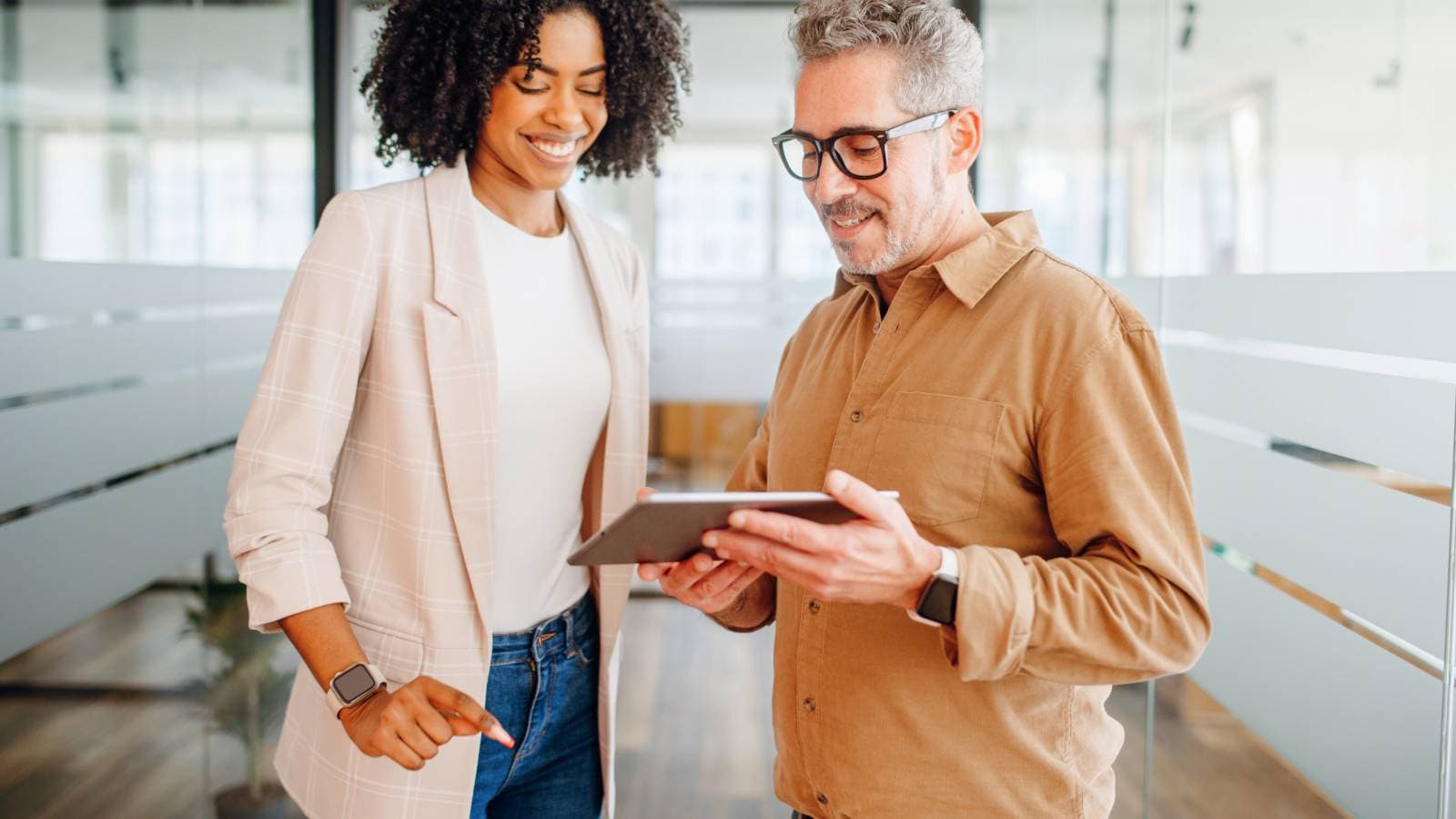 Two business professionals looking at a tablet