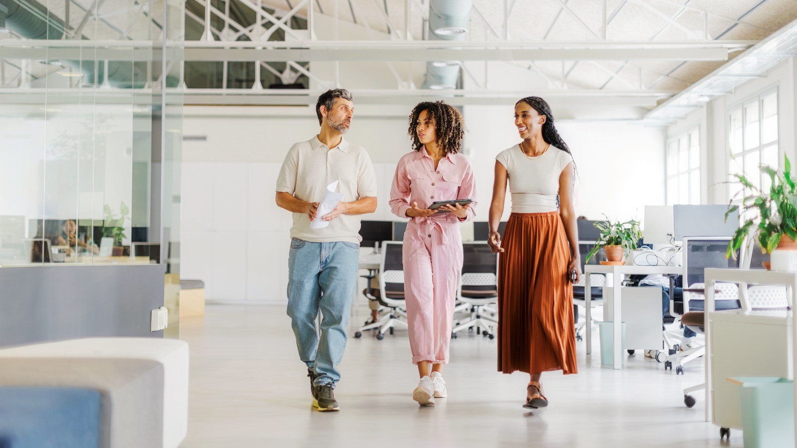 Group of colleages in a walking in a modern-designed office together.
