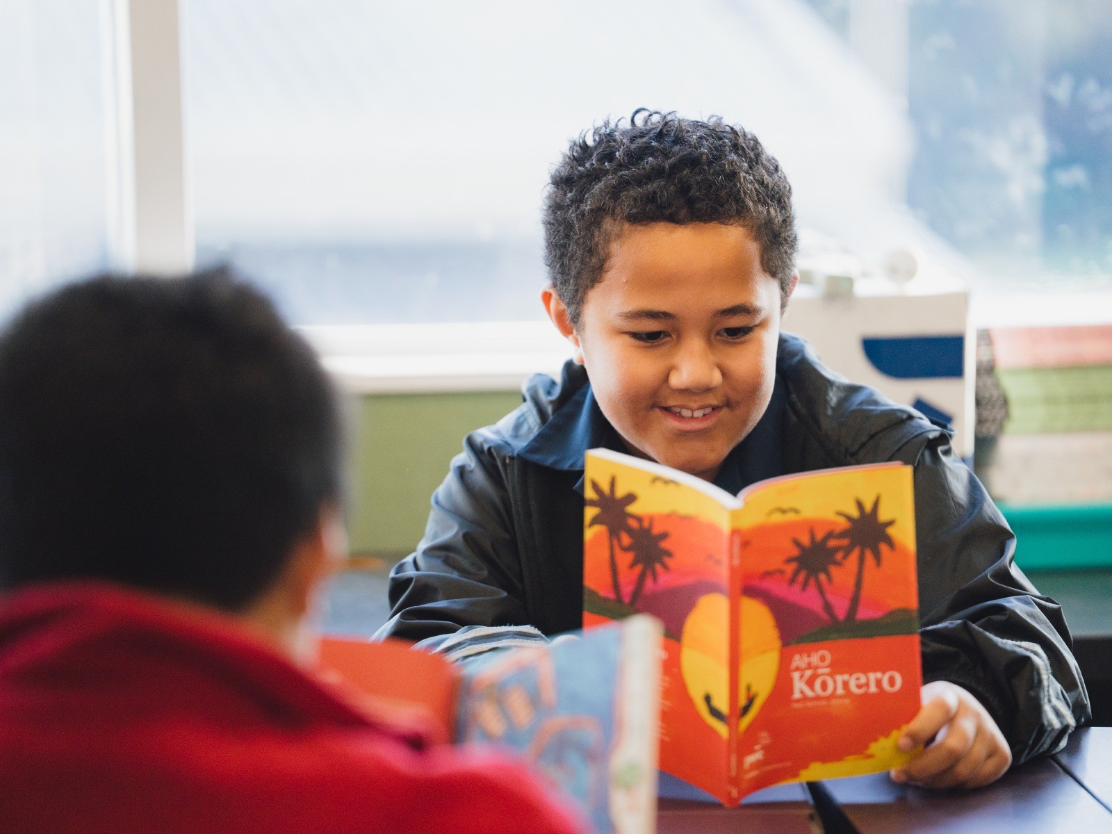 Children in a classroom reading Aho korero
