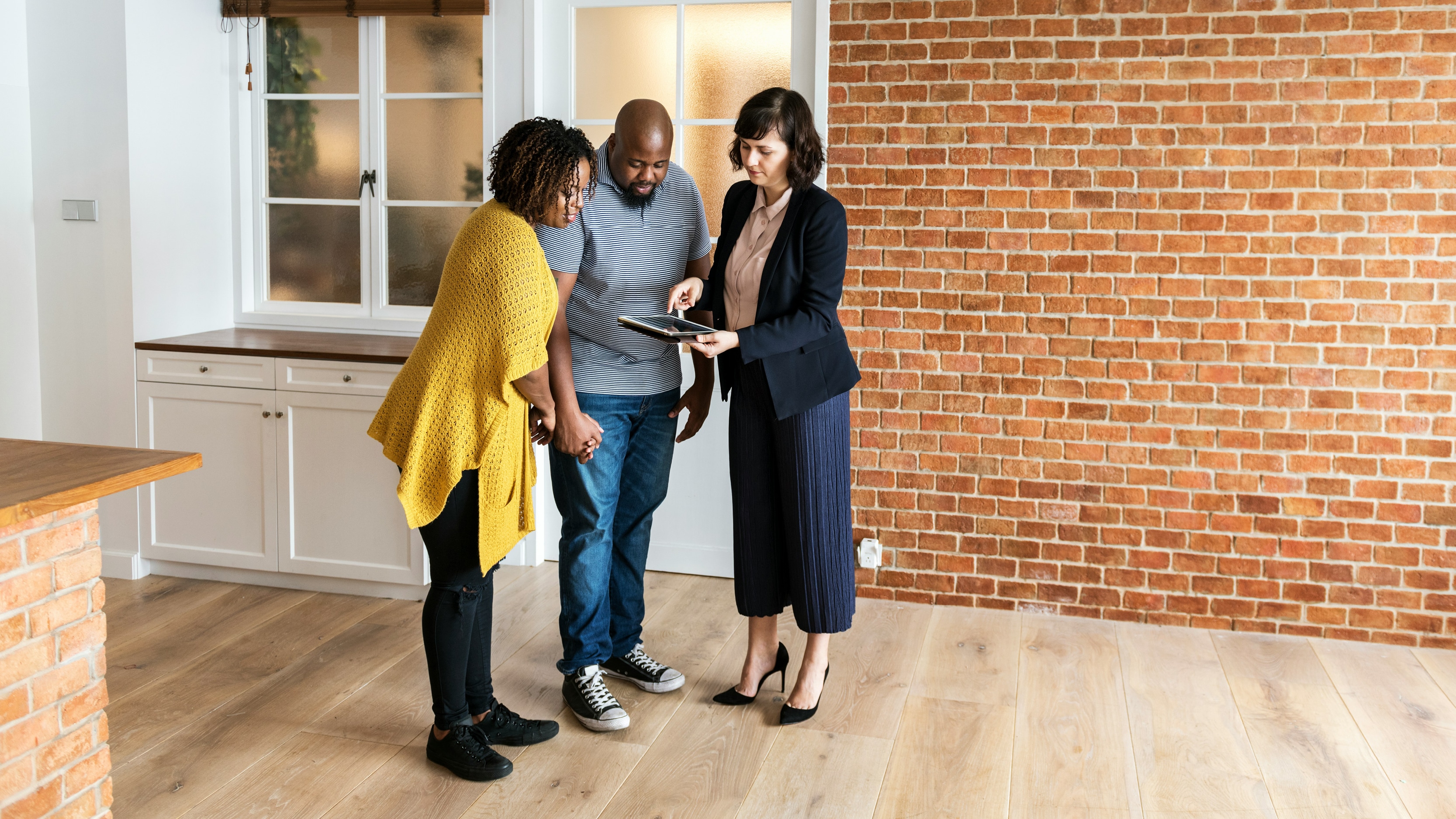 Real Estate agent showing people to an open home
