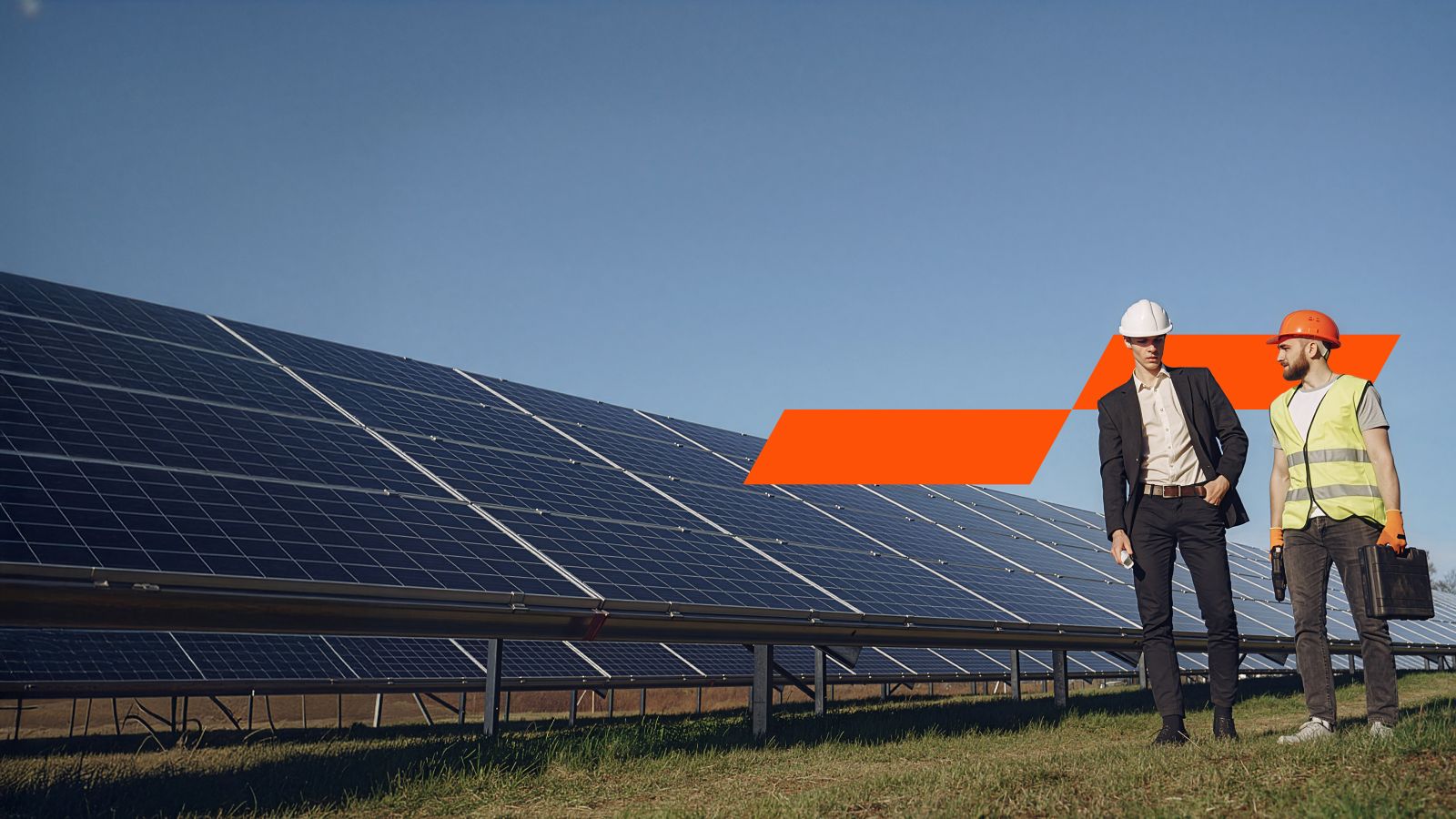Two people outside next to solar panels
