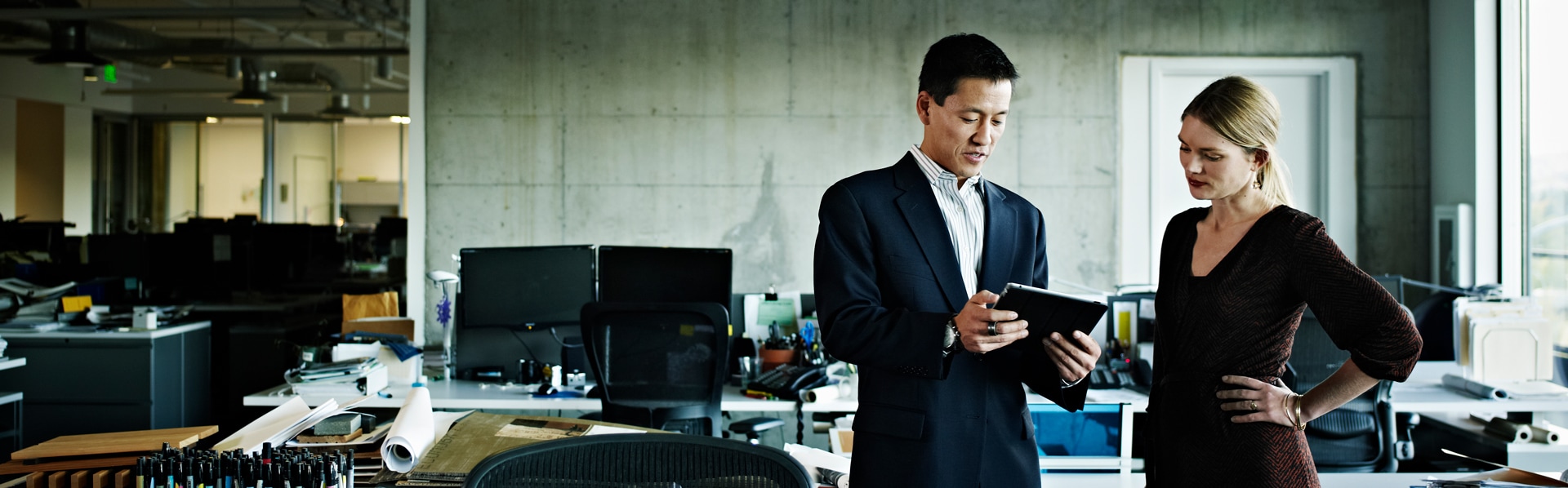 Two colleagues discussing with a tablet on hand.